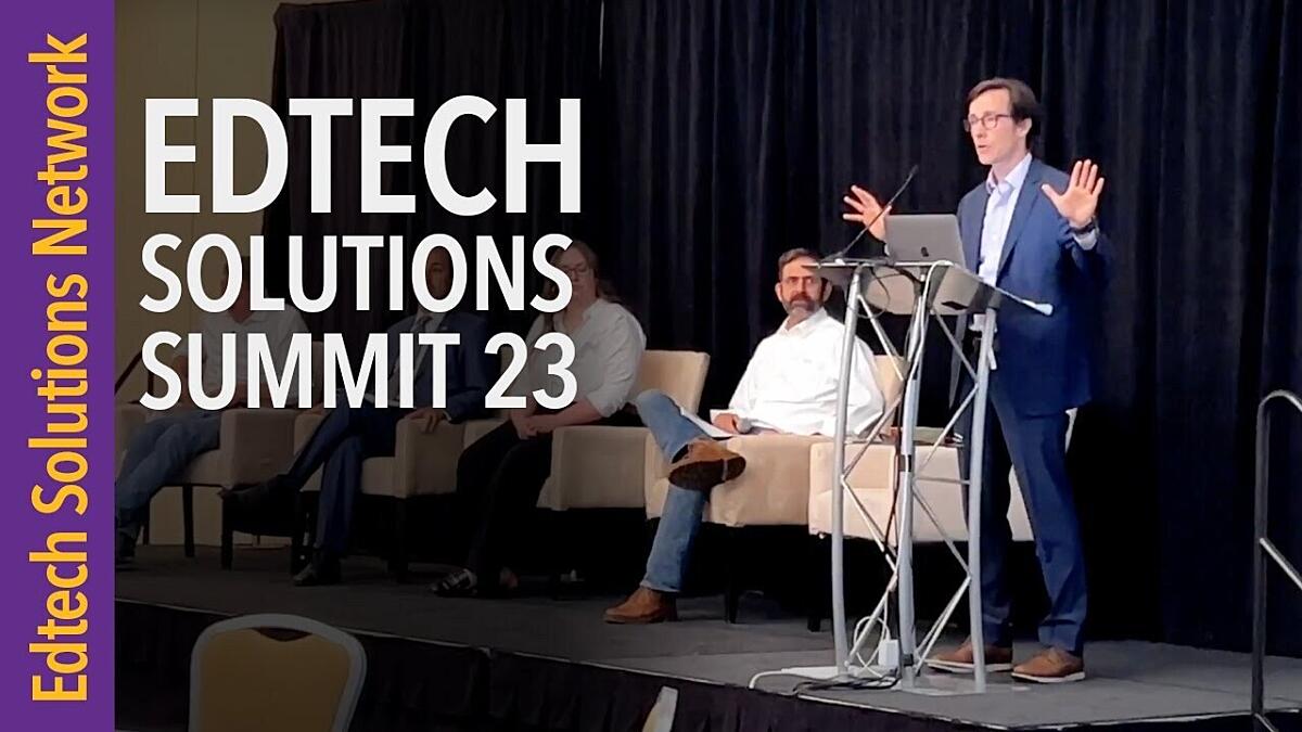 A photo of a white man at a podium on a small stage is gesturing with his arms as he speaks to an off-camera audience. The words Edtech Solutions Network and Edtech Solutions Summit 23 are superimposed over the left side of the image.