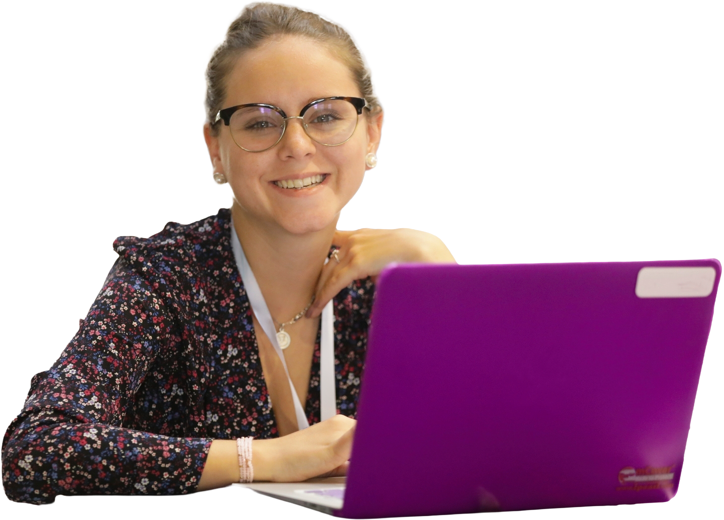 A woman wearing glasses and working at a bright purple laptop.