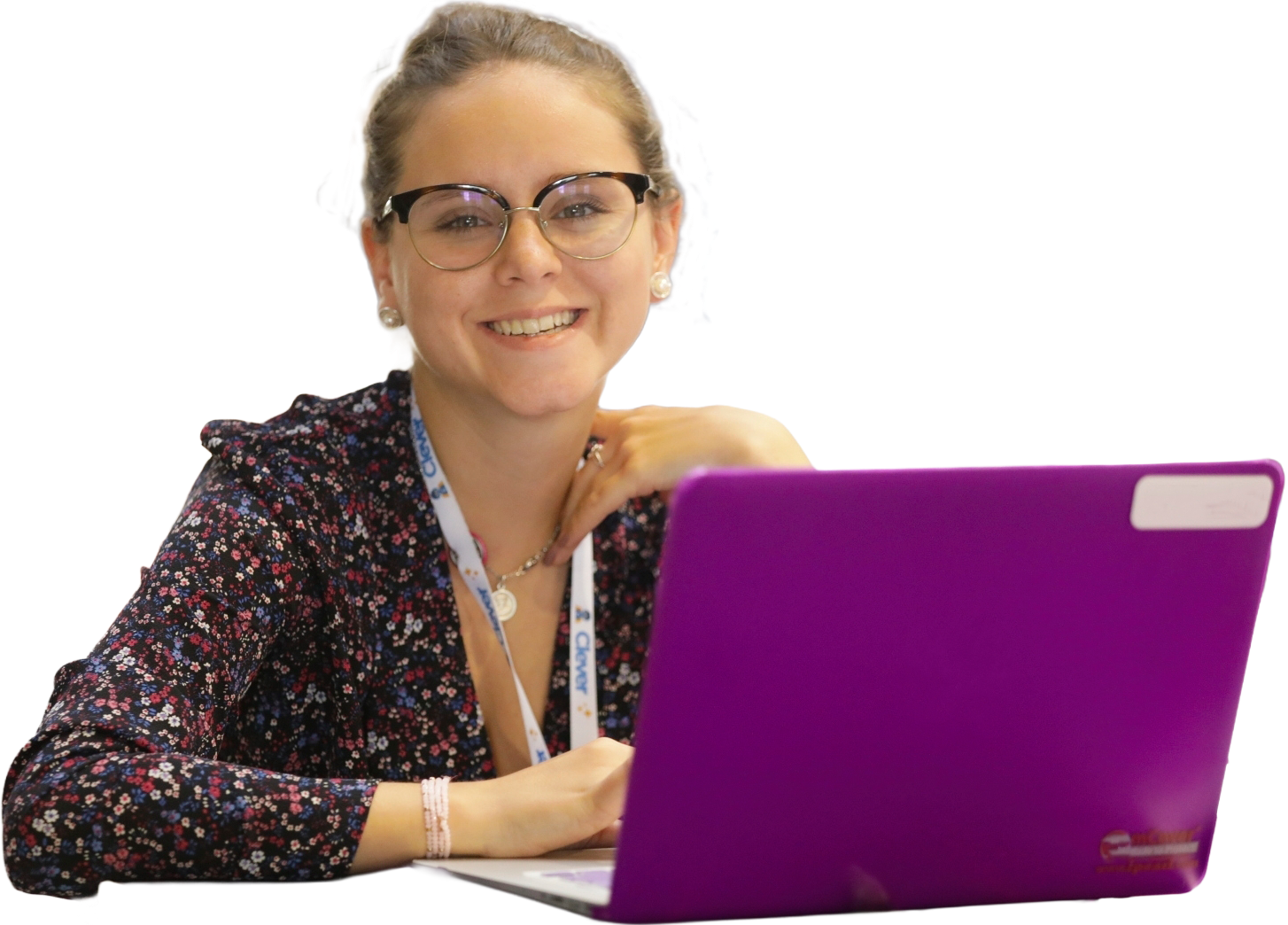 A woman wearing glasses and working at a bright purple laptop.